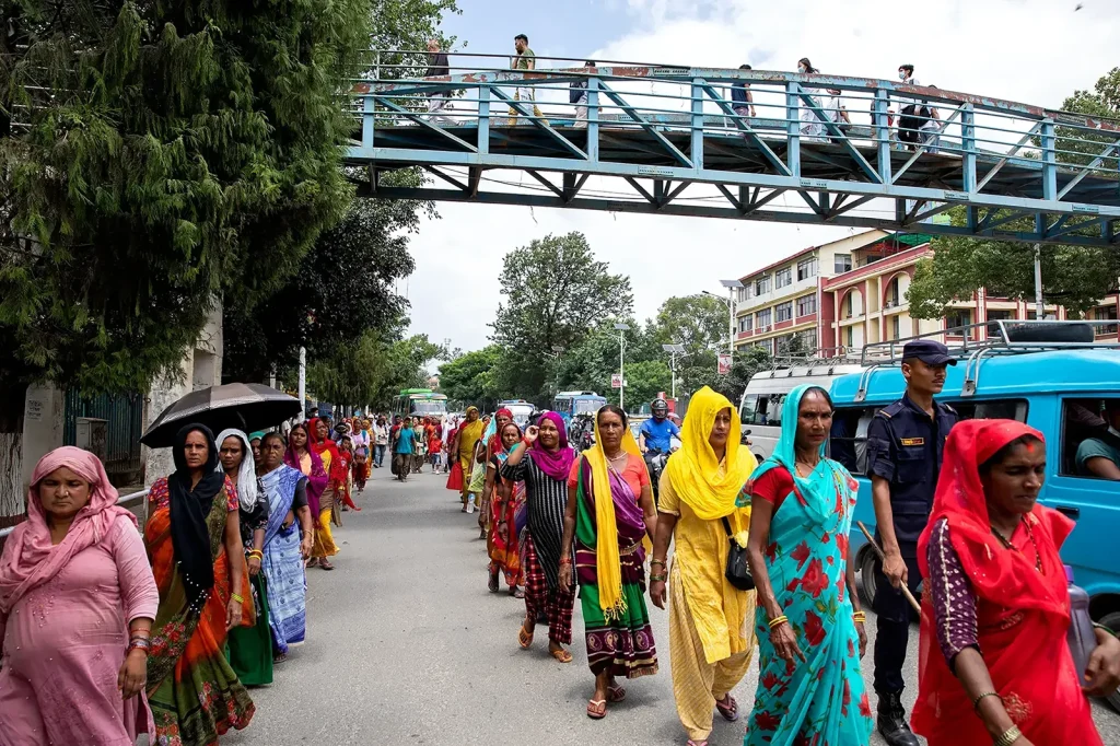 Grupo de mulheres nepalesas com saris coloridos em marcha de protesto na rua em Katmandu, Nepal, julho 2023 — manifestação das vítimas de agiotagem Meter-Byaj, documentada pela fotojornalista Carlota Leitão
